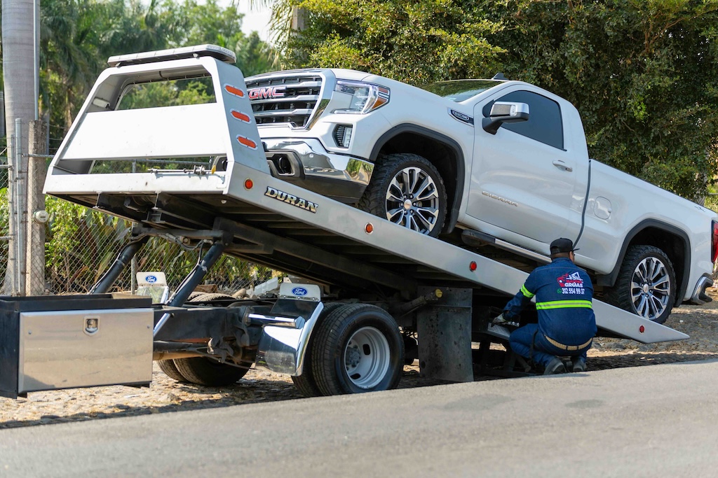 Tow truck driver loading a vehicle on a roadside service call